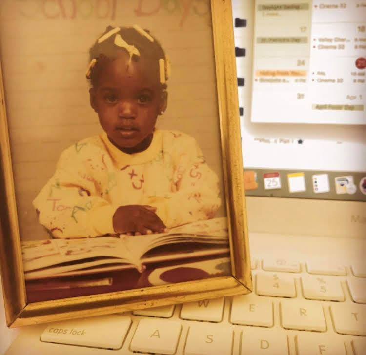 Picture of Jennifer as a baby with hands on an open book